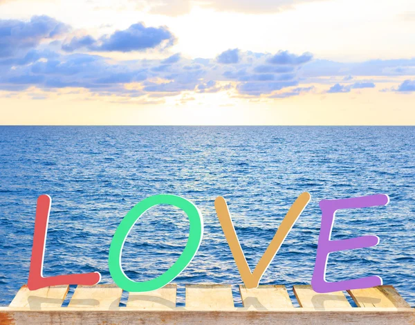 Word Love with old wood table and tropical sea and pastel sky on — Stock Photo, Image