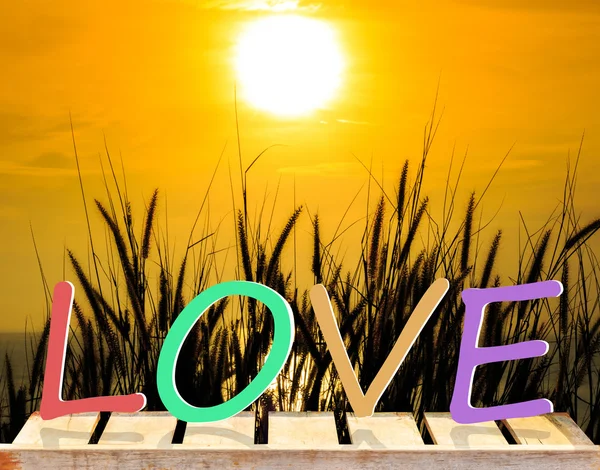 Word Love with old wood table and dust cloud and red sunset back — Stock Photo, Image