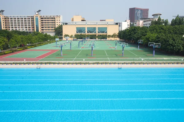 Piscina e campo da basket, attrezzature sportive scolastiche — Foto Stock