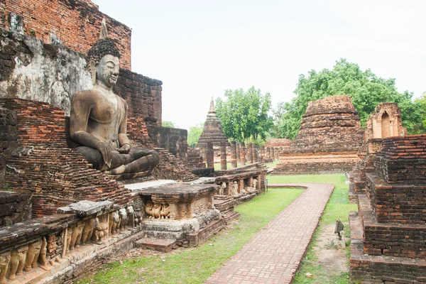 Istuu Buddha veistos joukossa rauniot Sukhothai historiallinen — kuvapankkivalokuva