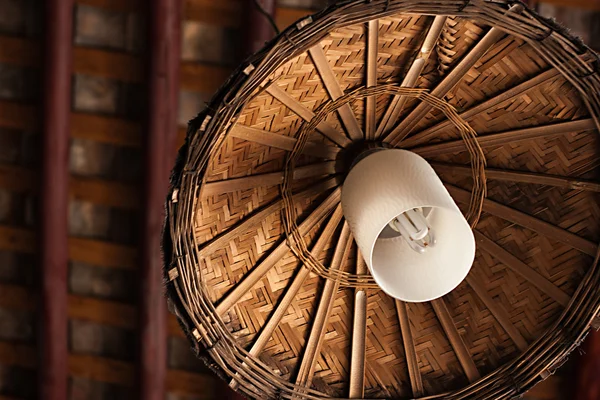 Çatının altında asılı bambu abajurlu lamba.