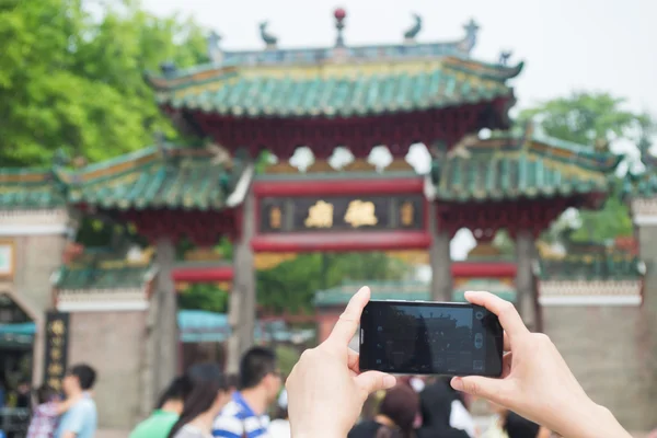 Mulher usando um telefone celular para tirar fotos — Fotografia de Stock