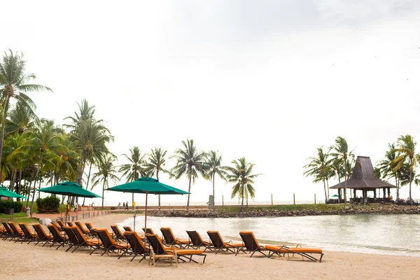 Strandkorb und Sonnenschirm am Meer — Stockfoto