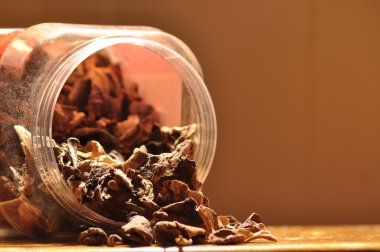 Kapsayıcıdan dökülmesini kurutulmuş mantar. Gıda katkı maddeleri. Orman meyveleri. Sonbaharda hasat.