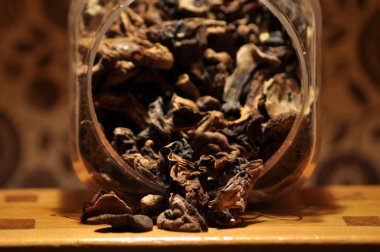 Kapsayıcıdan dökülmesini kurutulmuş mantar. Gıda katkı maddeleri. Orman meyveleri. Sonbaharda hasat.