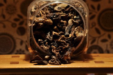 Kapsayıcıdan dökülmesini kurutulmuş mantar. Gıda katkı maddeleri. Orman meyveleri. Sonbaharda hasat.