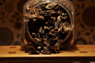 Kapsayıcıdan dökülmesini kurutulmuş mantar. Gıda katkı maddeleri. Orman meyveleri. Sonbaharda hasat.