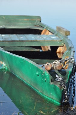 Kürek teknesi kıyıya demirlemiş. Nehirde bahar. Yüzen.