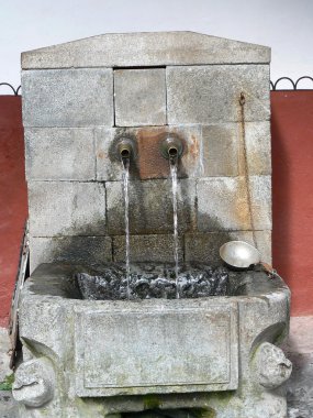 Rila Manastırı dağlarda. Kutsal su kaynağıdır. Kepçe ve musluklar... Sütunlar ve mimarisi. Bulgaristan'ın turistik yer.