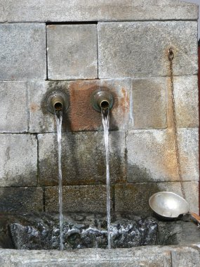 Rila Manastırı dağlarda. Kutsal su kaynağıdır. Kepçe ve musluklar... Sütunlar ve mimarisi. Bulgaristan'ın turistik yer.