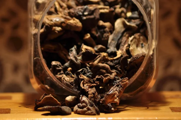 Kapsayıcıdan dökülmesini kurutulmuş mantar. Gıda katkı maddeleri. Orman meyveleri. Sonbaharda hasat.