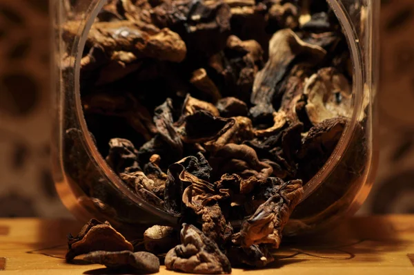 Kapsayıcıdan dökülmesini kurutulmuş mantar. Gıda katkı maddeleri. Orman meyveleri. Sonbaharda hasat.