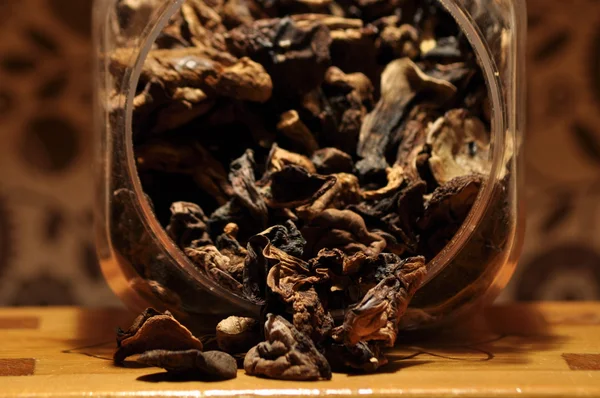 Kapsayıcıdan dökülmesini kurutulmuş mantar. Gıda katkı maddeleri. Orman meyveleri. Sonbaharda hasat.