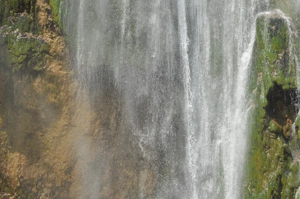 Alta cachoeira, a água que flui das rochas para o lago. Parque Nacional dos Lagos Plitvice. Turismo na Croácia . — Fotografia de Stock