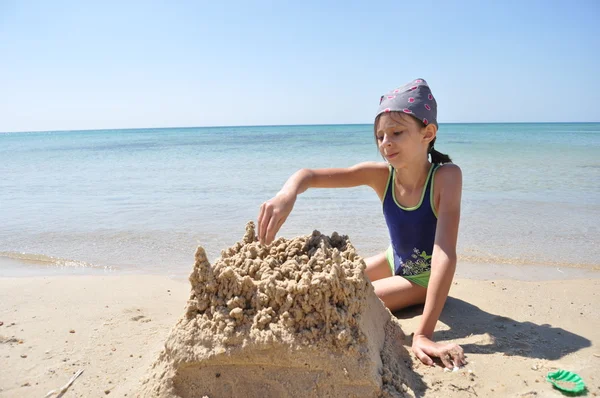 Kız sahilde Kumdan kale oluşturur. Egzotik bir ülkede tatil