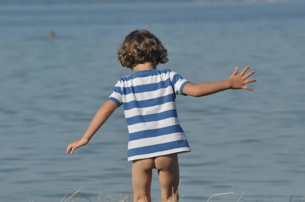 Un bambino che desidera entrare in acqua. Tempo libero in vacanza. Lago . — Foto Stock