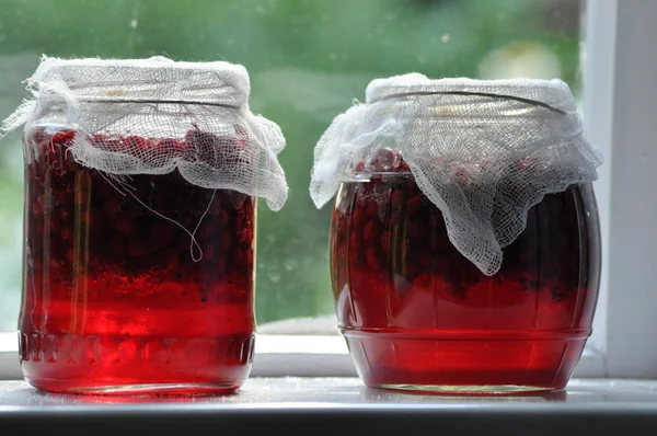 Kavanoz kavanoz reçel çiftlik pencere üzerinde duran kırmızı kuş üzümü ile. Bahçeye.