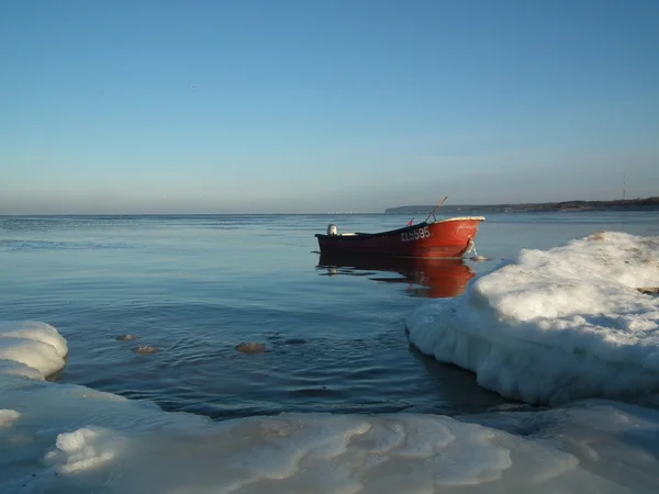 얼음 바다에 빨간 보트 계 류. 겨울 해. — 스톡 사진