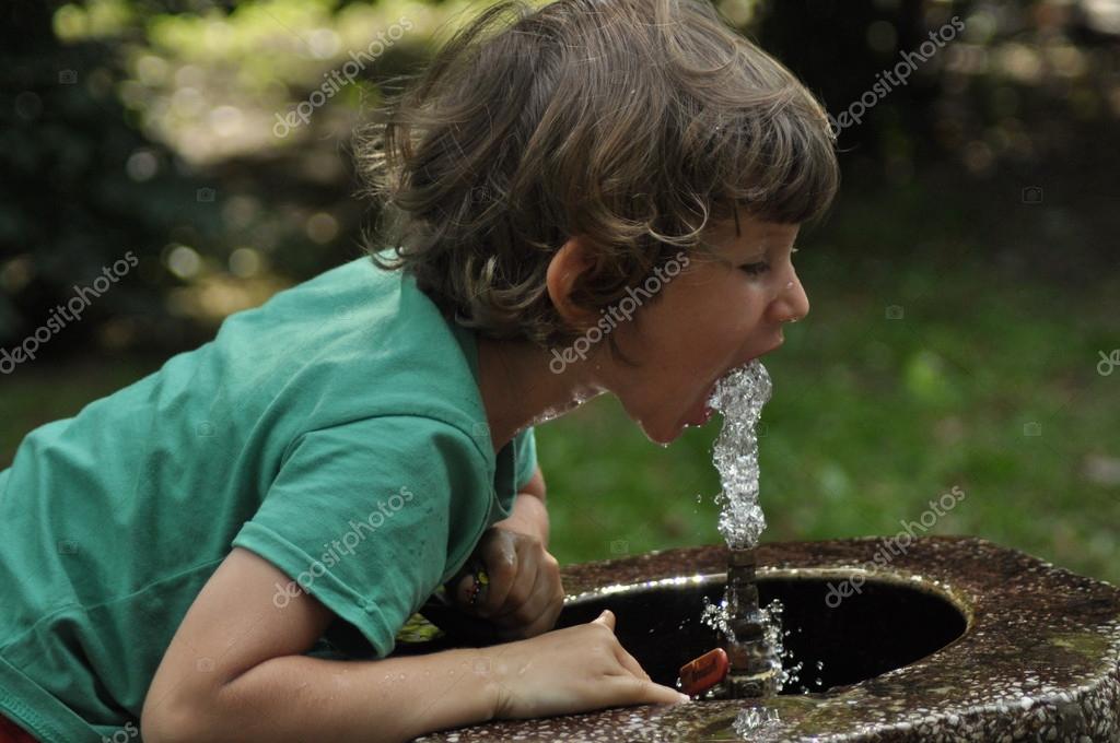 kid drinking water from fountain