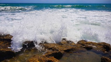 Beyaz köpük dalgası kayalara çarpıyor.