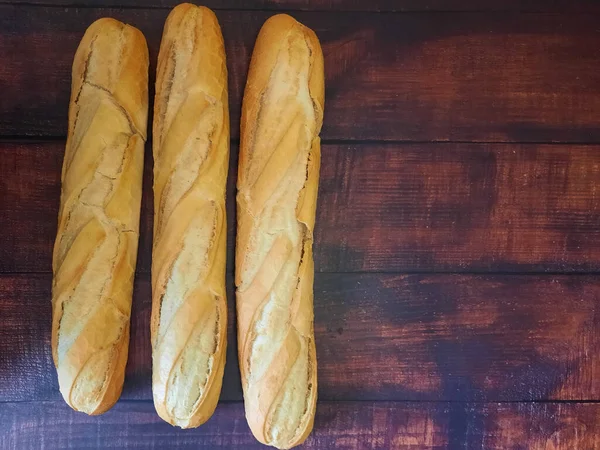 新烤好的木制工作台上的面包 — 图库照片