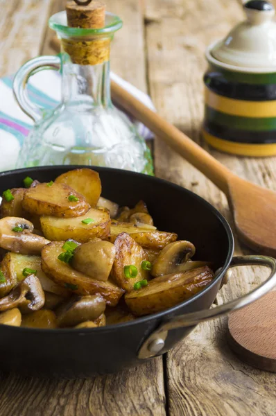 Batatas fritas com cogumelos em uma panela de ato de fritar — Fotografia de Stock