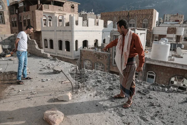 Taiz / Yemen - 22 Ağustos 2016: Yemen 'in Taiz kentindeki evinde Houthi milislerinin ateşlediği bombanın neden olduğu yıkıma bir Yemenli bakıyor