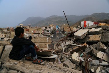Taiz / Yemen - 13 Nisan 2017: Taiz şehrinde el-Houthi milisleri ile ulusal ordu arasında çıkan şiddetli çatışmalar sonucu yıkılan evlerin arasında çocuk