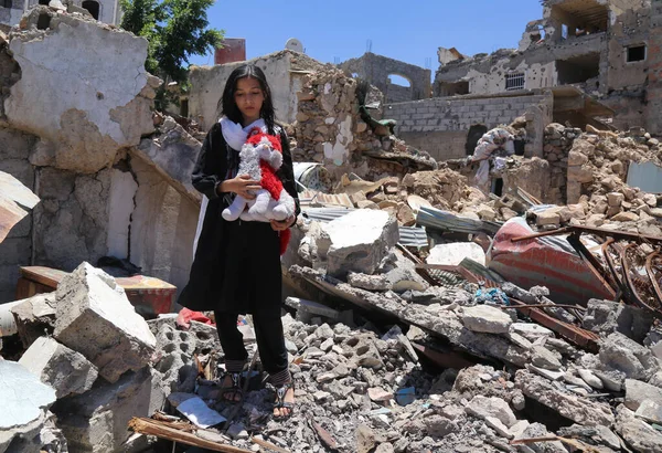 Taiz / Yemen - 13 Nisan 2017: El-Houthi milisleri ile Taiz City, Yemen 'deki ulusal ordu arasındaki şiddetli çatışmayla yıkılan harabeler arasında bir kız