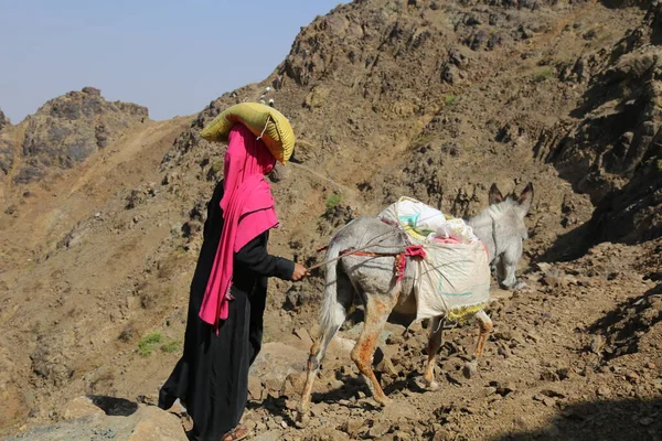 Taiz / Yemen - 02 Nisan 2017: Taiz kentindeki Houthi milis barikatı nedeniyle Yemen 'li kadınlar yiyecek ve içecek ihtiyaçlarını engebeli dağ yollarından geçirdiler