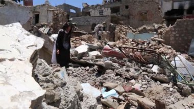 Taiz / Yemen - 13 Nisan 2017: Taiz Şehir Yürüyüşü 'nden Yemenli kız, kentteki savaş nedeniyle yıkılmış evinin kalıntıları üzerinde