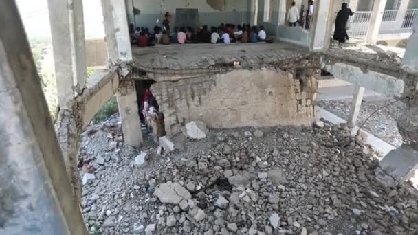 Taiz_イエメン_07 10月2020 悲しいイエメンの子供は イエメンのタイズ市で戦争によって破壊された彼女の学校のホールでカメラを見ています — ストック動画