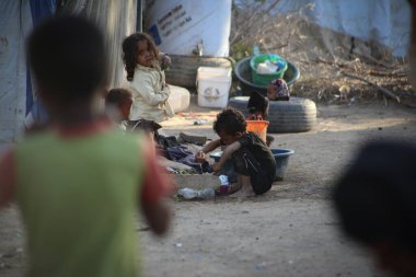 Taiz, Yemen- 04 Şubat 2021: Yemenli çocuklar ve kadınlar, Taiz kentindeki savaş yüzünden evlerinden sürgün edildikten sonra yerlerinden edilenler için açık bir kampta yaşıyorlar.
