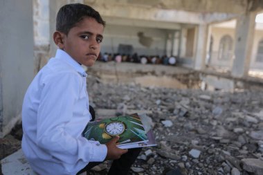 Taiz _ Yemen - 07 Ekim 2020: Üzgün bir Yemenli çocuk okulunun enkazında oturuyor, savaş tarafından yok edildi