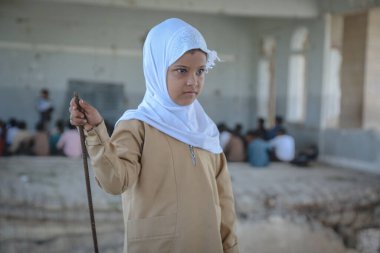 Taiz / Yemen - 07 Ekim 2020: Hüzünlü bir Yemenli kız, Taiz 'deki savaşın tahrip ettiği bir okulda okuyor