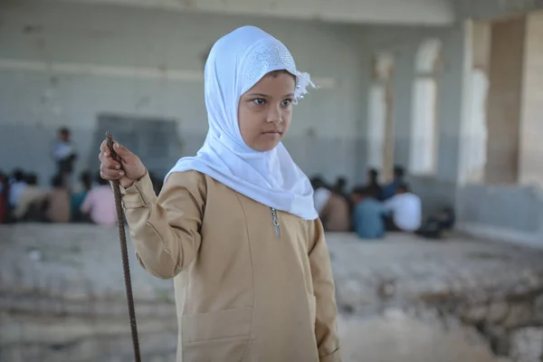 Taiz / Yemen - 07 Ekim 2020: Hüzünlü bir Yemenli kız, Taiz 'deki savaşın tahrip ettiği bir okulda okuyor