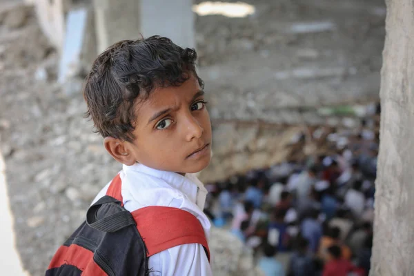 Taiz _ Yemen - 07 Ekim 2020: Üzgün bir Yemenli çocuk okulunun enkazında oturuyor, savaş tarafından yok edildi