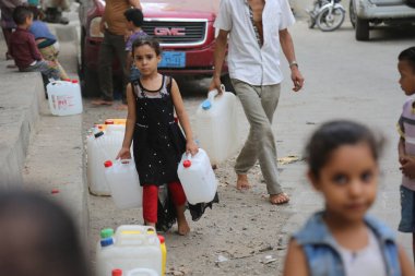 Taiz / Yemen - 13 Ağustos 2020: Su krizi ve savaşın başlangıcından bu yana Güney Yemen 'deki Taiz şehrinin sakinlerinin tanık olduğu zor yaşam koşulları nedeniyle çocuklar su almaya gittiler