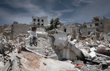  Taiz _ Yemen _ 13 Nisan 2017: Hüzünlü bir çocuk Yemen 'deki savaş yüzünden yıkılmış evinin enkazında oturuyor, Taiz 