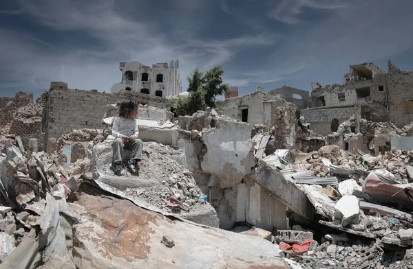  Taiz _ Yemen _ 13 Nisan 2017: Hüzünlü bir çocuk Yemen 'deki savaş yüzünden yıkılmış evinin enkazında oturuyor, Taiz 