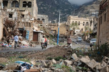 Taiz _ Yemen _ 29 Nisan 2021: Yemen 'deki savaşta yıkılan evlerin yıkıntıları üzerinde yürüyen Yemenliler, Taiz