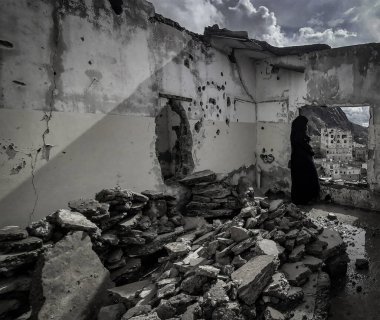 Taiz _ Yemen _ 03 Mayıs 2021: Yemen 'in Taiz kentinde devam eden savaş sırasında yıkılan bir evde Yemen' li bir kadın duruyor
