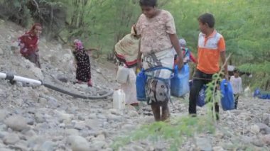 Taiz, Yemen- 18 Şubat 2021: Yemen 'deki su krizi nedeniyle çocuklar ve kadınlar su getiriyor