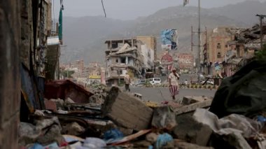 Taiz Yemen - 16 Aralık 2016: Yemeni, Taiz kentinde savaş sırasında yıkılan evlerin yıkıntıları üzerinde yürüyor