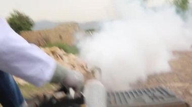 Taiz / Yemen - 20 Temmuz 2020: Bir Yemenli doktor Taiz kırsalında Chikungunya hastalığına yakalanan sivrisineklerle savaşmak için sis püskürttü