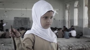 Taiz Yemen - 07 Ekim 2020: Üzgün bir Yemenli çocuk, Yemen 'in Taiz kentindeki savaşta yok olan okul salonundaki kameraya bakıyor