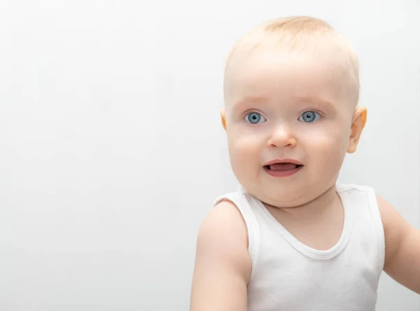 Menino loiro bebê com grandes olhos blu em materiais eco-friendly roupas em casa. — Fotografia de Stock