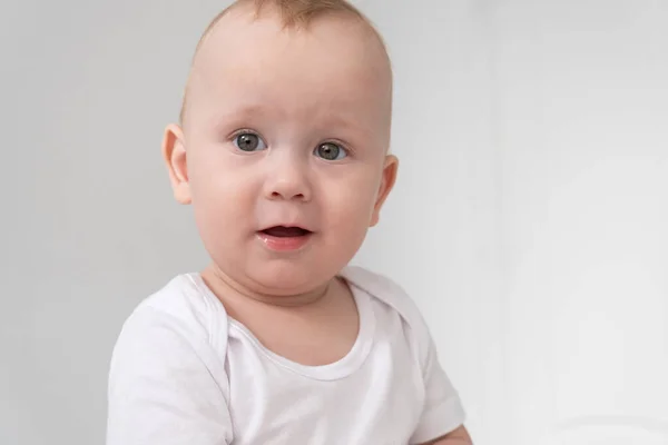 Engraçado bebê menino sorrindo no branco quarto em casa. — Fotografia de Stock