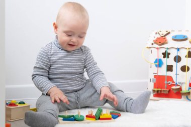 Erkek bebek işlek tahta ve tahta oyuncaklarla oynuyor. Erken çocuk gelişimi