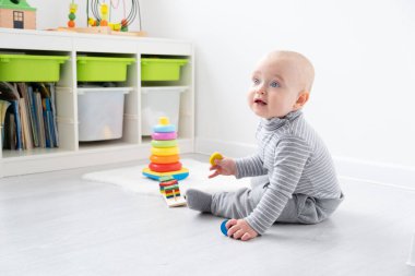 Erkek bebek piramit ve tahta oyuncaklarla oynuyor. Erken çocuk gelişimi.